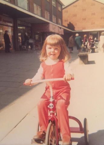 Jules White as a child on her red tricycle.